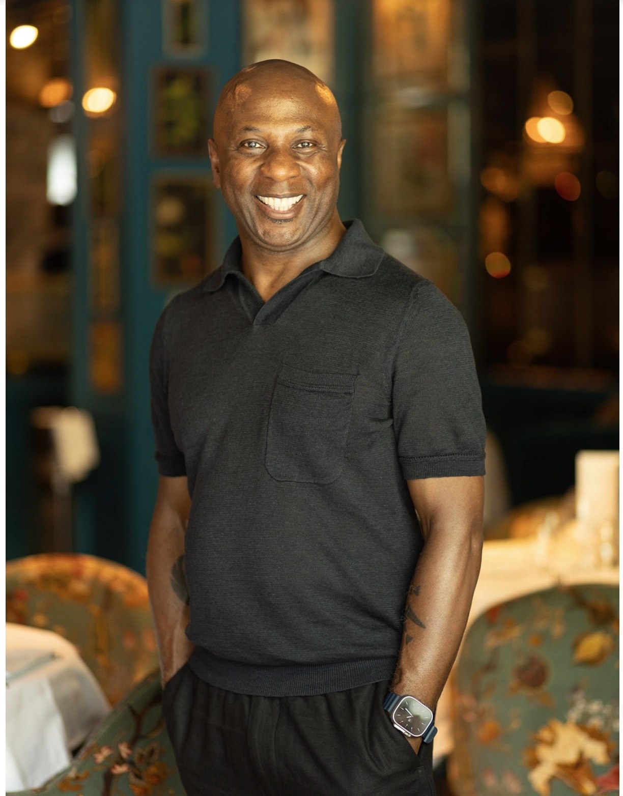 Full-length portrait of Robert Stephenson smiling in a restaurant setting